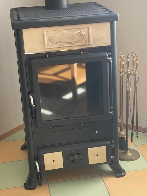 Gusseiserner Kaminofen mit Kaminbesteck