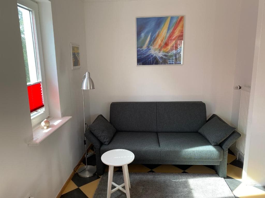 Sitzecke mit grauem Sofa und Stehlampe auf gefliestem Boden