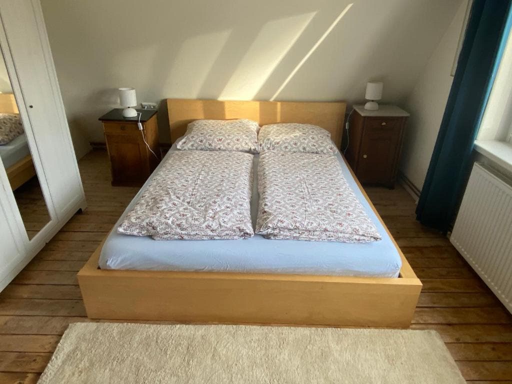 Elternschlafzimmer mit Doppelbett und Spiegelschrank unter der Dachschräge