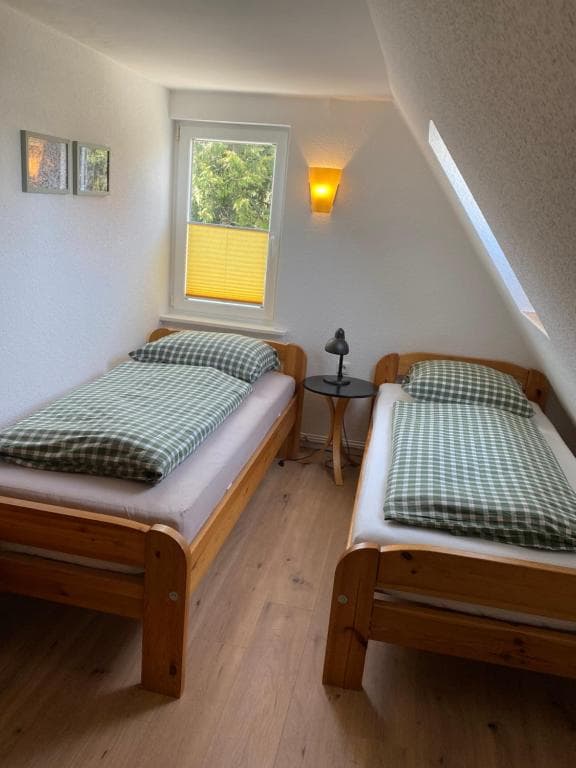 Zwei Einzelbetten unter der Dachschräge mit Nachttisch dazwischen