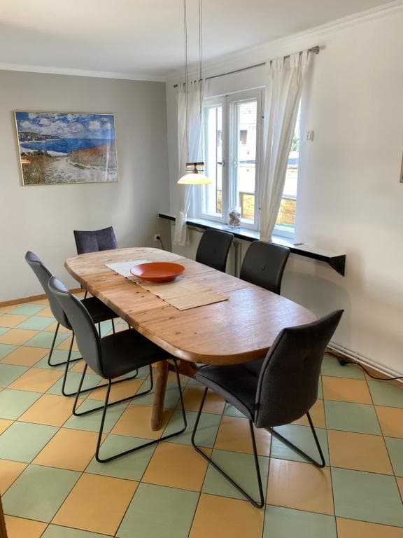 Esstisch mit schwarzen Stühlen direkt am Fenster
