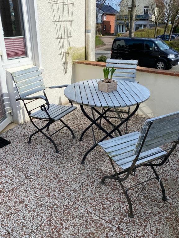 Runder Gartentisch mit zwei Klappstühlen auf der Kiesterrasse